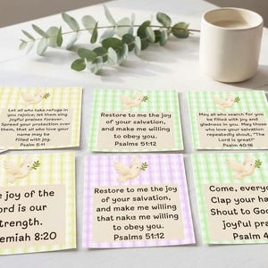 May include: A collection of square cards featuring a light green or light purple gingham pattern, each displaying a white dove illustration with an olive branch and printed Bible verses including Psalms 51:12, Psalms 40:16, and Nehemiah 8:20.