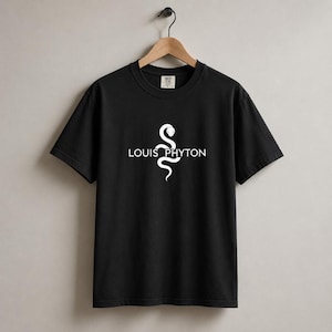 Könnte beinhalten: Ein schwarzes Kurzarm-T-Shirt mit einer weißen Grafik einer vertikal gewundenen Schlange in der Mitte. Der Text LOUIS PHYTON ist in weißen Großbuchstaben über die Mitte der Schlangengrafik gedruckt. Das T-Shirt hängt an einem Holzkleiderbügel.