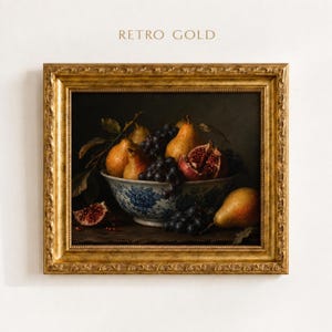 May include: A framed still life painting titled RETRO GOLD featuring a bowl of fruit including pears, grapes, and a pomegranate. The bowl has a blue and white floral pattern. The ornate frame is gold with a textured, carved edge design.