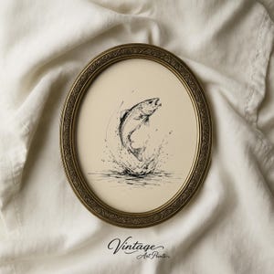 Peut inclure: Un cadre ovale de style ancien en or avec un motif de bordure gaufré complexe. À l'intérieur du cadre se trouve une impression couleur crème présentant une illustration à l'encre noire d'un poisson sautant hors de l'eau, créant un effet d'éclaboussure.
