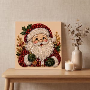 May include: A square wall art piece featuring a Santa Claus portrait crafted from small, round, multi-colored beads. The design includes a red hat, a white beard, green and red accents, and gold-toned decorative sprigs on a light background.