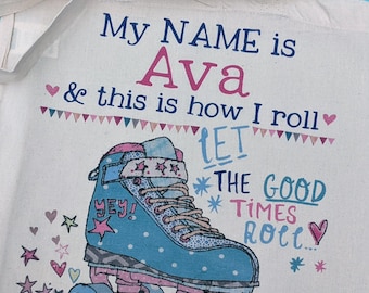 May include: A natural-coloured canvas tote bag featuring a graphic of a blue roller skate with pink accents. The text reads: My NAME is Ava & this is how I roll, LET THE GOOD TIMES ROLL. Small pink and blue hearts and stars decorate the design.
