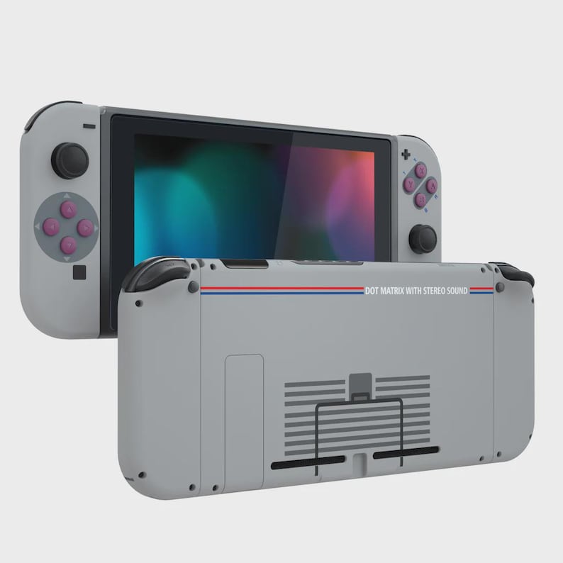 May include: A light gray handheld gaming console featuring a screen, detachable controllers with purple buttons, and a rear casing printed with the text DOT MATRIX WITH STEREO SOUND, accented by a thin horizontal blue and red stripe across the back.