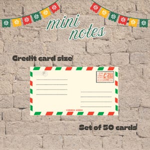 May include: A set of 50 credit card size mini notes featuring an airmail envelope design with red and green diagonal border stripes, a postage stamp, and the text Correo Aereo. The cards are displayed with a festive banner of floral pennants.