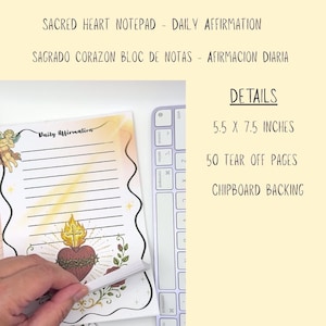 May include: A Sacred Heart notepad with 50 tear-off pages, measuring 5.5 x 7.5 inches with chipboard backing. The notepad features a Daily Affirmation header, a winged cherub, and a flaming heart illustration with a cross and floral accents.