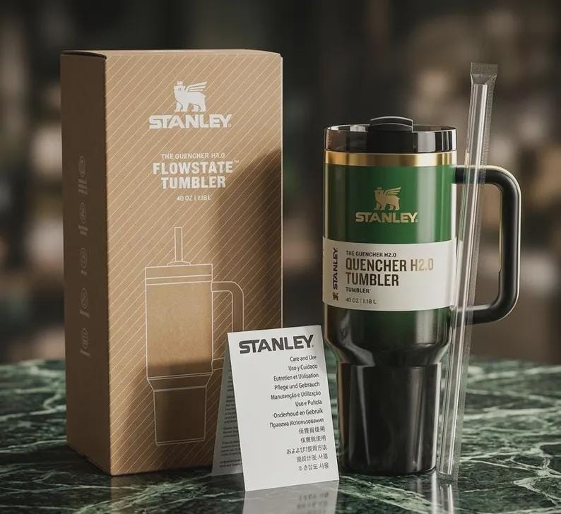 Puede incluir: Un vaso Stanley Quencher H2.0 Flowstate verde y negro con asa y pajita. El vaso es de 1,18 L y viene con una caja de cart&oacute;n e instrucciones de cuidado. El logotipo de Stanley es visible.