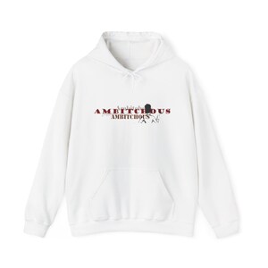 May include: White hoodie with a front pocket and drawstring hood. The word "AMBITCHOUS" is printed across the chest in a distressed, red font, with a silhouette graphic and the word "AMBITCHOUS" below.