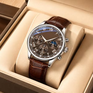 May include: A silver-tone chronograph watch with a brown dial, Roman numeral hour markers, and a brown leather strap with a crocodile-embossed texture. The watch features three sub-dials, a moon phase indicator, and a tachymeter scale on the bezel.