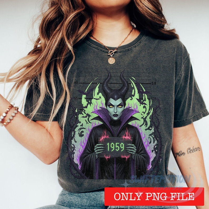 K&ouml;nnte beinhalten: Ein anthrazitfarbenes T-Shirt mit einer Grafik einer gr&uuml;nh&auml;utigen Figur mit H&ouml;rnern, die ein schwarzes Gewand mit violettem Kragen tr&auml;gt. Die Figur h&auml;lt ein Schild mit der Aufschrift 1959 vor einem Hintergrund aus gr&uuml;nen Flammen und einer Messlatte.