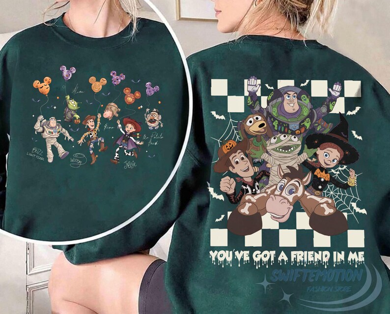 May include: A dark green crewneck sweatshirt featuring Toy Story characters in Halloween costumes. The back displays Buzz Lightyear, Woody, Jessie, and others with the text "YOU'VE GOT A FRIEND IN ME" over a checkered pattern. The front shows a smaller graphic of the characters holding Mickey-shaped balloons.