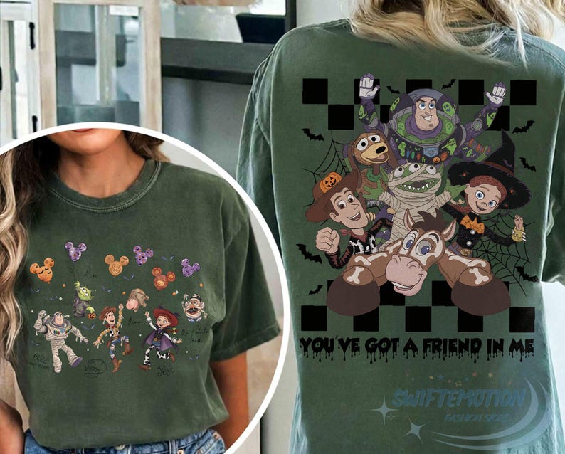 May include: A dark olive green t-shirt featuring Toy Story characters in Halloween costumes. The front shows small character graphics with Mickey-shaped balloons. The back displays a large graphic of the characters with the text You've Got A Friend In Me.