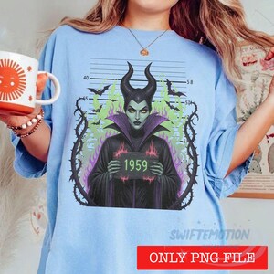 K&ouml;nnte beinhalten: Ein hellblaues T-Shirt mit einer Grafik einer geh&ouml;rnten Figur in schwarzem Gewand, die ein Schild mit der Aufschrift 1959 h&auml;lt. Die Figur ist von dornigen Ranken, gr&uuml;nen Flammen und Flederm&auml;usen vor einem Hintergrund mit Ma&szlig;skala umgeben.