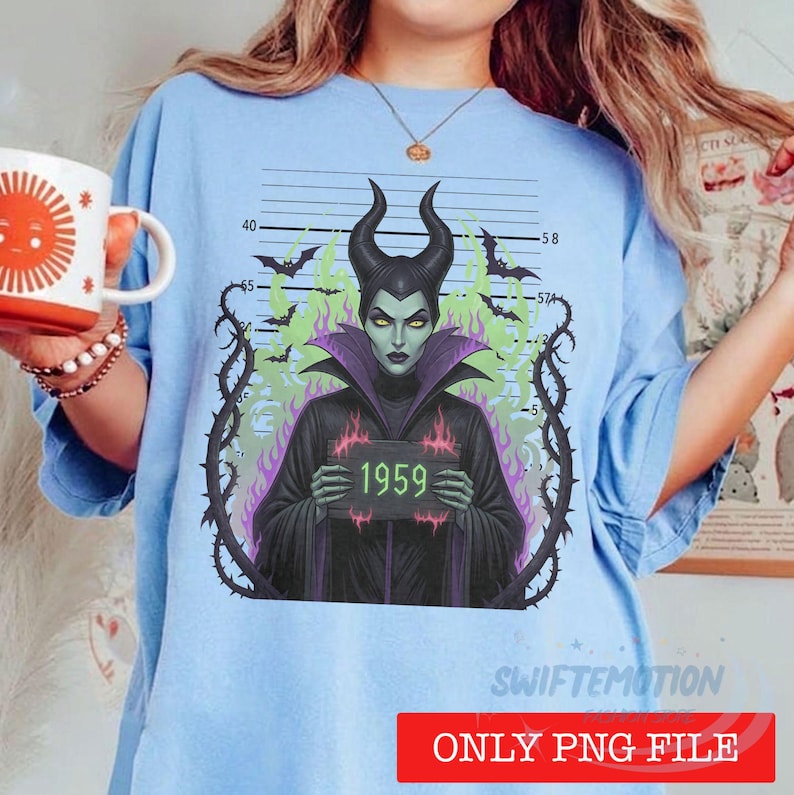 K&ouml;nnte beinhalten: Ein hellblaues T-Shirt mit einer Grafik einer geh&ouml;rnten Figur in schwarzem Gewand, die ein Schild mit der Aufschrift 1959 h&auml;lt. Die Figur ist von dornigen Ranken, gr&uuml;nen Flammen und Flederm&auml;usen vor einem Hintergrund mit Ma&szlig;skala umgeben.