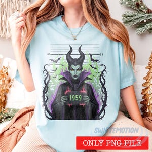 K&ouml;nnte beinhalten: Ein hellblaues T-Shirt mit einer Grafik einer geh&ouml;rnten Figur in schwarzer Robe, die ein Schild mit der Aufschrift 1959 h&auml;lt. Die Figur ist von einer polizeilichen Messskala, violetten und gr&uuml;nen Flammen sowie schwarzen Dornenranken umgeben.
