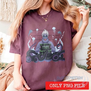 May include: A maroon short-sleeve t-shirt featuring a graphic of a purple-skinned character with white hair and tentacles holding a sign that reads 1989. The background of the graphic includes a height chart, jellyfish, and bubbles.