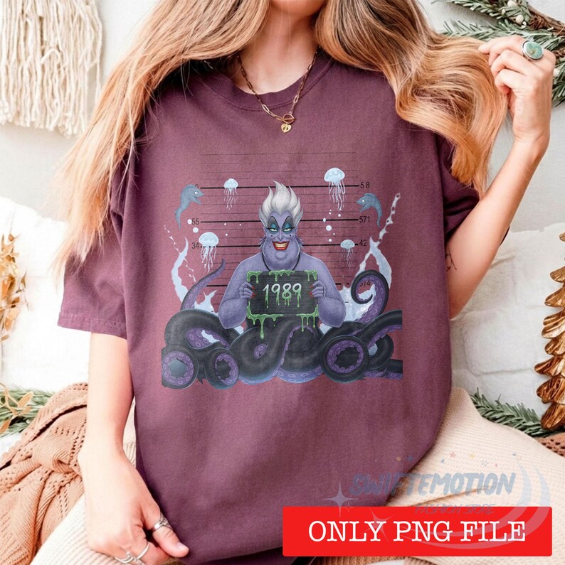 May include: A maroon short-sleeve t-shirt featuring a graphic of a purple-skinned character with white hair and tentacles holding a sign that reads 1989. The background of the graphic includes a height chart, jellyfish, and bubbles.