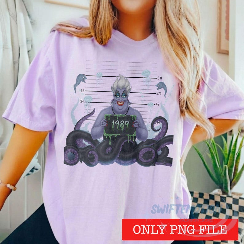 May include: A light purple short-sleeve t-shirt featuring a graphic of a purple sea witch with tentacles holding a sign that reads 1989. The design includes a mugshot-style background with horizontal lines, numbers, and small jellyfish illustrations.