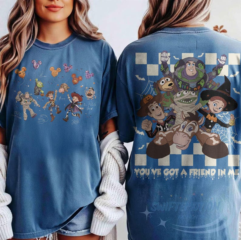 May include: A blue t-shirt featuring Toy Story characters. The front displays small illustrations of characters with Mickey-shaped balloons. The back shows a large graphic of Buzz Lightyear, Woody, Jessie, and Bullseye with the text YOU'VE GOT A FRIEND IN ME.