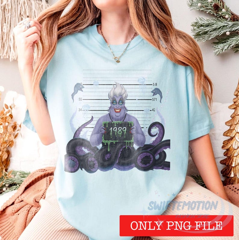 May include: A light blue t-shirt featuring a graphic of a purple sea witch with tentacles, posed in front of a police mugshot height chart. The character holds a sign with the text 1989 in green slime font, surrounded by jellyfish illustrations.
