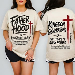 May include: A beige t-shirt featuring black text and a red cross. The front reads FATHER HOOD IS KINGDOM WORK, PROVERBS 22:6, and a verse. The back reads KINGDOM GENERATIONS IS THE LEGACY OF GODLY FATHERS, PSALM 112:2, and a verse.