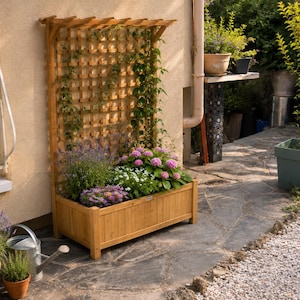 Puede incluir: Una jardinera rectangular de madera con un enrejado vertical adjunto. La jardinera contiene varias plantas verdes con flores rosas y moradas. La estructura está hecha de madera de color marrón claro y presenta un patrón de rejilla en la parte superior.
