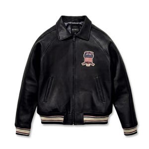 May include: A black leather jacket with a full-length front zipper, a classic collar, and ribbed cuffs and hem featuring white and maroon stripes. A patch on the left chest displays the text AVIREX above a shield with an American flag design.