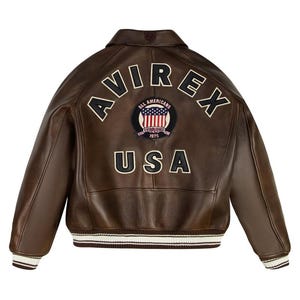 May include: A brown leather jacket featuring a large arched AVIREX logo in black and white lettering across the back. Below the logo is a circular patch with an American flag and the text ALL AMERICANS ESTABLISHED 1975, followed by USA.