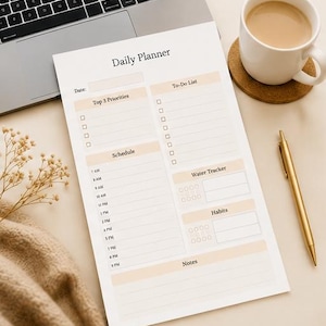 May include: A Daily Planner sheet with sections for date, top priorities, to-do list, schedule, water tracker, habits, and notes. The planner is on a light beige surface, next to a laptop, a cup of coffee, and a gold pen.