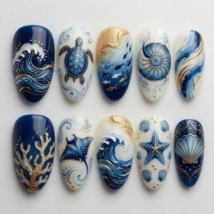 May include: A collection of ten artificial nails with ocean-themed designs. Each nail features intricate artwork, including waves, sea turtles, fish, and seashells, in shades of blue, white, and gold. The nails are oval-shaped and showcase detailed marine life illustrations.