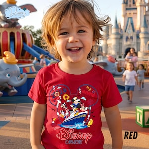 May include: A bright red short-sleeved t-shirt featuring a graphic of Disney characters on a cruise ship inside a Mickey Mouse head outline. The design includes the text "Disney Cruise" and "2026" with nautical icons like anchors and suns.