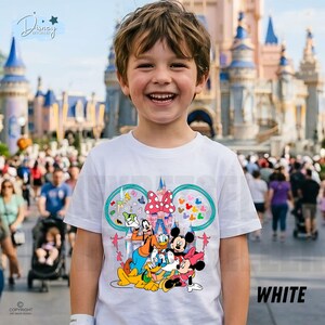 May include: A white t-shirt with a vibrant Disney character design, including Mickey and Minnie Mouse, Goofy, and Donald Duck. The shirt features a castle design and the word "WHITE" is printed on the bottom right.