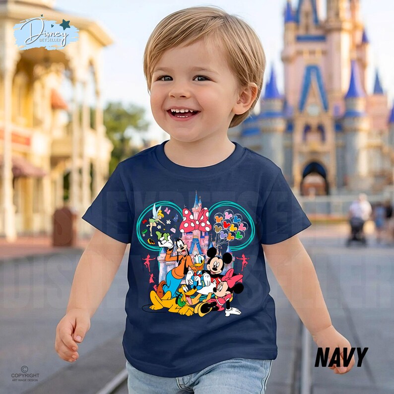 May include: Navy blue t-shirt with a Disney character graphic, including Mickey and Minnie Mouse, Donald Duck, and Goofy. The design features a castle and balloons. The word "NAVY" is printed on the bottom right.