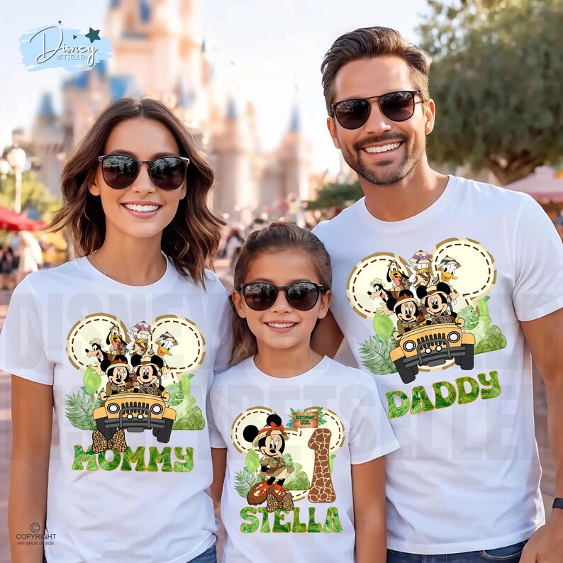 May include: White t-shirts with a Mickey Mouse safari design. The shirts feature Mickey, Donald, Goofy, and Pluto in a jeep. One shirt says "Mommy", another says "Daddy", and the third says "Stella" with a number 1 and a giraffe.