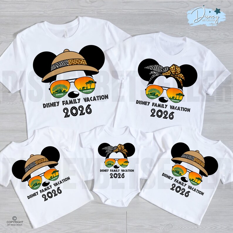 May include: White t-shirts with a Mickey Mouse design, featuring safari hats, sunglasses, and the text "DISNEY FAMILY VACATION 2026". The shirts are in various sizes, including a baby onesie, perfect for a family vacation.