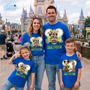 May include: A family of four wearing matching blue t-shirts with Disney character designs. The shirts feature Mickey Mouse, Donald Duck, and other characters in a jeep. The shirts say "Mommy", "Daddy", "Sister", and "Janson".