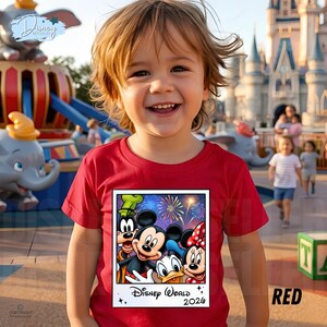 Puede incluir: Una camiseta roja con un gr&aacute;fico de los personajes de Disney Mickey Mouse, Minnie Mouse, Goofy y Donald Duck con fuegos artificiales y el texto "Disney World 2026". La camiseta la lleva un ni&ntilde;o sonriente.