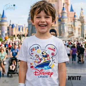 May include: A white short-sleeved t-shirt featuring a graphic of Mickey Mouse, Minnie Mouse, and Goofy on a cruise ship inside a large Mickey ear outline. The design includes the text 2026, NAME, and Disney Cruise in red and blue colours.