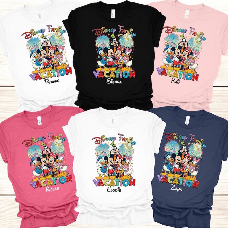 May include: A collection of Disney Family Vacation t-shirts in various colors, including white, black, pink, and navy. Each shirt features a colorful graphic of Disney characters and the text "VACATION" with a personalized name. The shirts are short-sleeved.