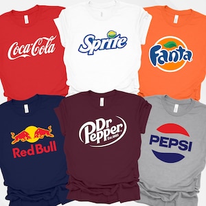 May include: A collection of six t-shirts in various colors, each featuring a different soda brand logo. The shirts include Coca-Cola, Sprite, Fanta, Red Bull, Dr. Pepper, and Pepsi. The logos are in their original colors and designs.