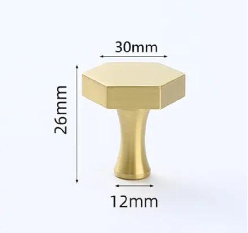 May include: A gold-colored hexagonal cabinet knob with a smooth finish. The knob features a flat top measuring 30mm in width, a base width of 12mm, and a total height of 26mm as indicated by the black dimension lines and arrows in the image.