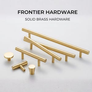 May include: A collection of solid brass hardware, including cabinet pulls and knobs. The set features various sizes and styles, such as bar pulls, T-shaped pulls, and round knobs. The text "FRONTIER HARDWARE" and "SOLID BRASS HARDWARE" are displayed at the top.