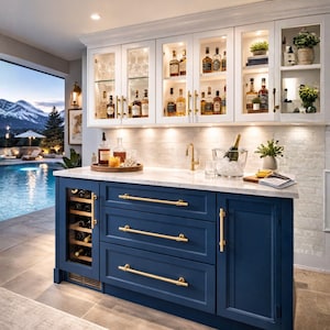 May include: A home bar with a navy blue cabinet, marble countertop, and white upper cabinets. The bar features a wine cooler, drawers with gold handles, and a sink with a gold faucet. The upper cabinets display various bottles of liquor and glassware.