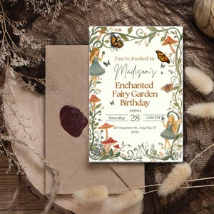 Puede incluir: Una tarjeta de invitaci&oacute;n de cumplea&ntilde;os rectangular con fondo crema y un borde de enredaderas verdes, setas rojas y mariposas. El texto dice: You're Invited to Madison's Enchanted Fairy Garden Birthday, 28 de agosto, 4:00 PM.