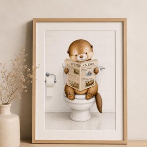 Könnte beinhalten: Ein gerahmter Kunstdruck, der einen braunen Otter zeigt, der auf einer weißen Toilette sitzt und eine Zeitung mit dem Titel Otter News liest. Der Hintergrund zeigt weiße Fliesenwände und einen Toilettenpapierhalter. Der Otter hat hellbraunes Fell.
