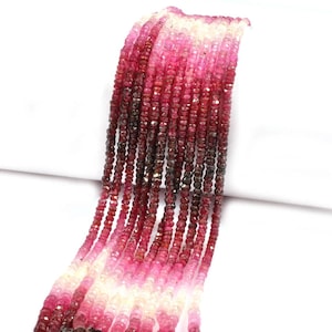 May include: A collection of multiple strands of faceted gemstone beads arranged in a vertical display. The beads exhibit a colour gradient transitioning from deep dark red and magenta at the centre to lighter pink and translucent white at the ends.