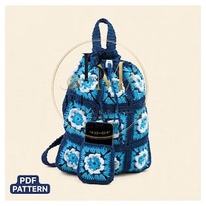 May include: A crochet backpack constructed from square motifs in shades of dark blue, light blue, and white. The bag features a drawstring closure, a top handle, and a small matching front pocket containing a black smartphone. A PDF PATTERN label is visible.