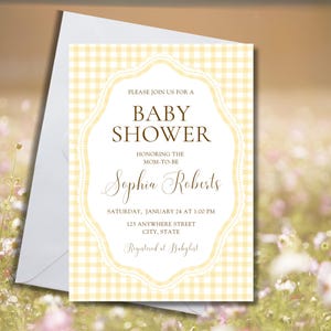 Può includere: Un invito per un baby shower con uno sfondo a motivo gingham giallo e una cornice decorativa. L'invito include il testo "Baby Shower" e i dettagli dell'evento, incluso il nome "Sophia Roberts". Accompagnato da una busta bianca.