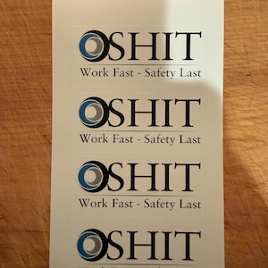 May include: Four white stickers with the text "OSHIT" in black, with a blue and gray circular design above the text. Below the text is the phrase "Work Fast - Safety Last" in black.