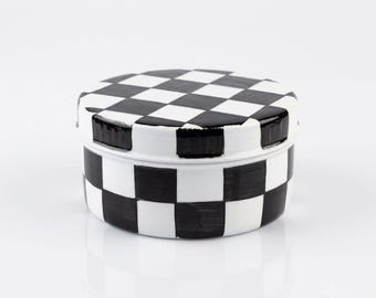 Fiambrera pintada a mano con diseño de cuadros en blanco y negro.