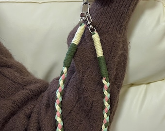 Hand-woven paracord phone strap in white and green, brightly colored woven rope bag decorations.